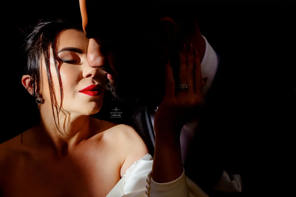 Mireasă și mire într-un moment intim, surprinși cu lumină direcțională dramatică – fotografie emoțională cu storytelling vizual.
