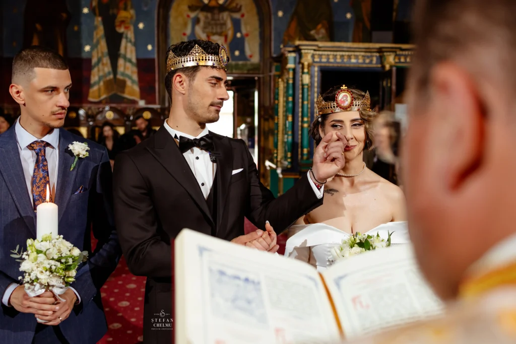 Mire și mireasă purtând cununii în timpul slujbei religioase, moment solemn de conexiune surprins de Ștefan Chelmu, fotograf nuntă Galați.