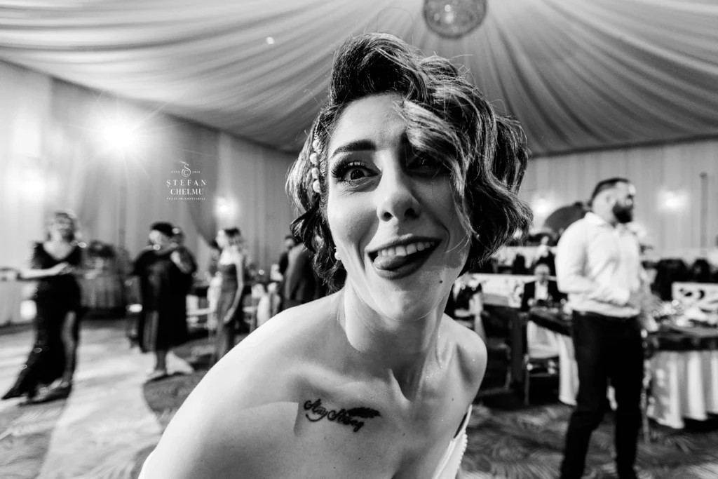 Mireasă relaxată făcând o grimasa amuzantă spre aparatul foto, ilustrând conceptul de prezență conștientă la nuntă, fotograf Ștefan Chelmu.